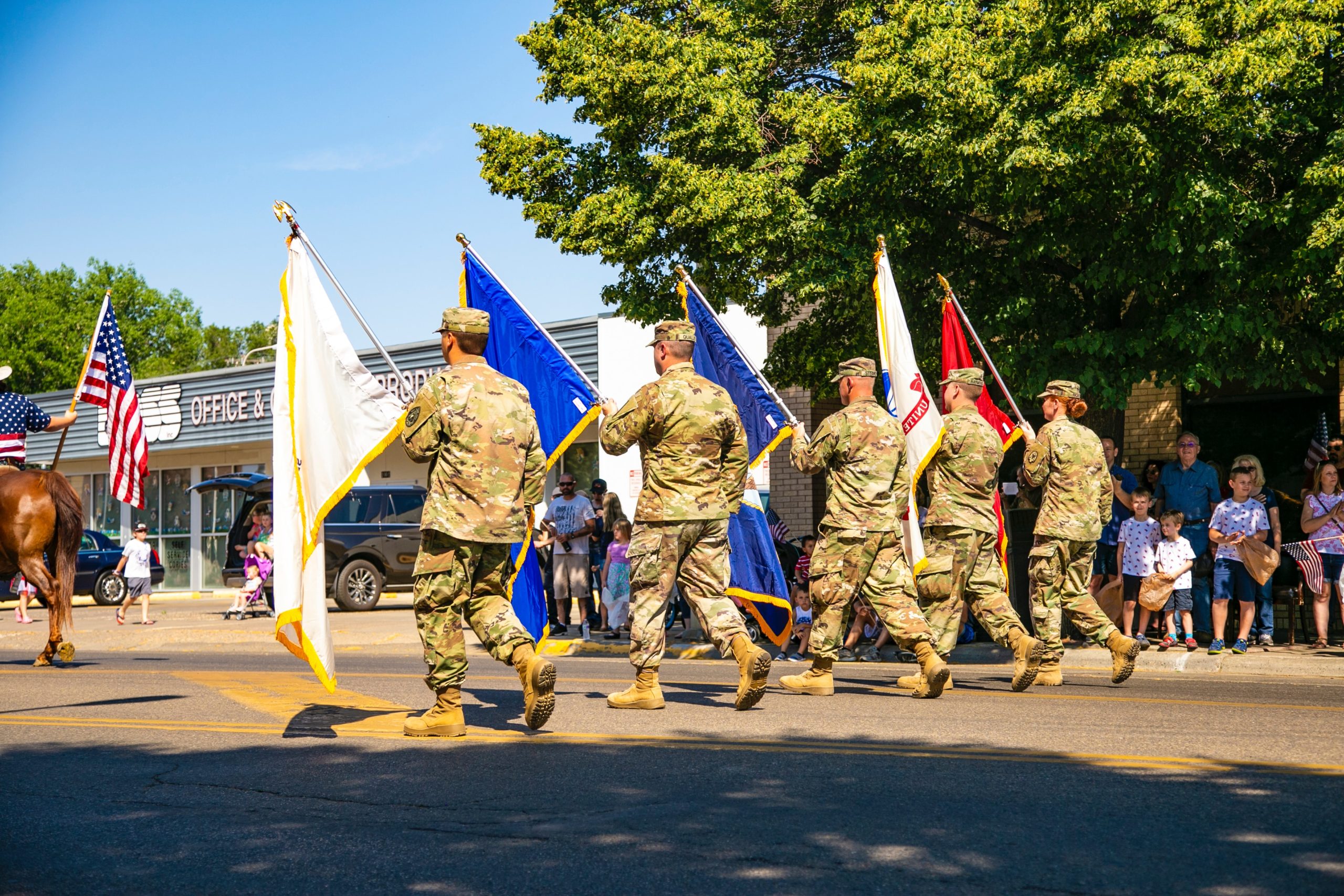 Five Military Members marching with flags